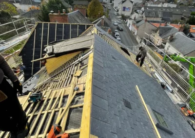 Couvreurs rénovant une toiture en ardoise au-dessus d’une rue