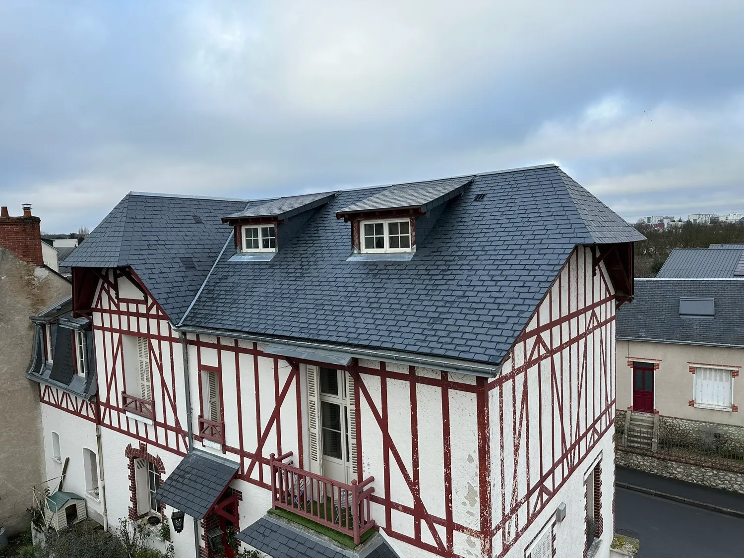 Maison à colombages rouges sous ciel nuageux