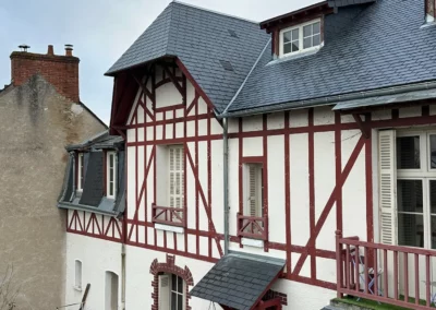 Maison à colombages rouges et blancs sous ciel nuageux