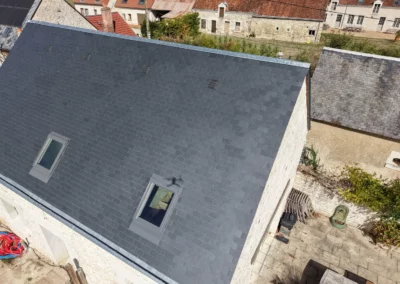 Toiture en ardoise rénovée avec deux fenêtres de toit