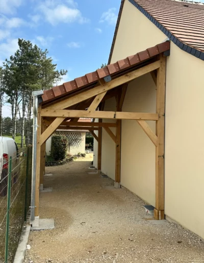 Auvent en bois adossé à une maison crépie