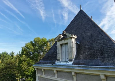 Toiture en ardoise avec lucarne sous ciel bleu