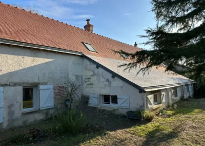 Maison ancienne aux volets blancs et toiture en tuiles