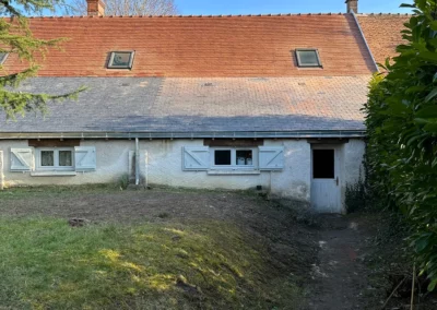 Maison rustique au toit de tuiles sous ciel bleu