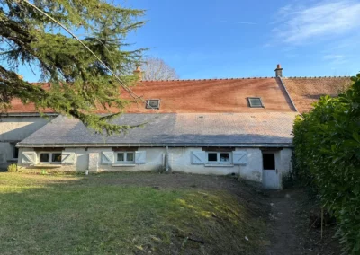 Maison ancienne avec volets bleus et toiture en tuiles