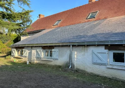 Maison traditionnelle aux volets bleus sous ciel dégagé