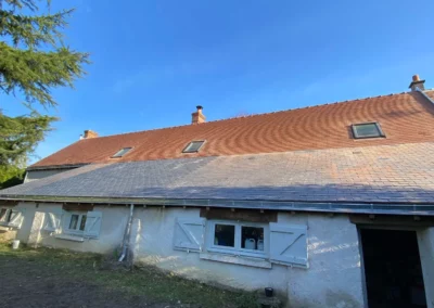 Maison rurale au toit en tuiles sous ciel bleu