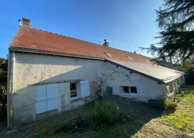 Maison ancienne aux volets blancs et toit en tuiles