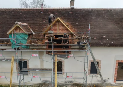 Couvreurs rénovant la toiture d’une maison sur échafaudage