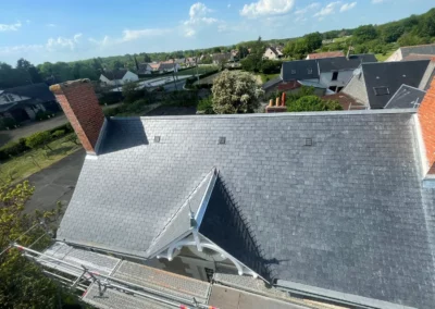 Toiture en ardoise rénovée avec échafaudage dans un village