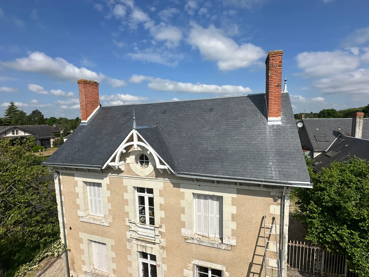 Toit en ardoise d’une maison ancienne avec cheminées