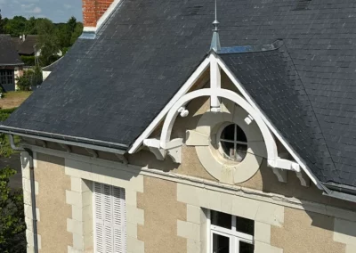 Toiture en ardoise d’une maison avec cheminée en brique