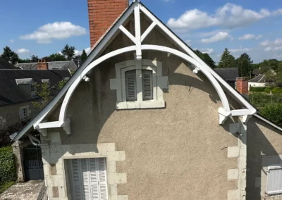 Pignon de maison ancienne avec charpente blanche et cheminée