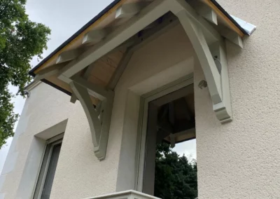 Auvent en bois au-dessus d’une entrée de maison