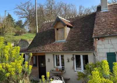 Maison de campagne au toit ancien entourée de fleurs