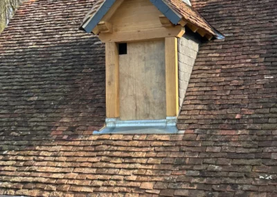 Lucarne rénovée sur toit ancien en tuiles plates