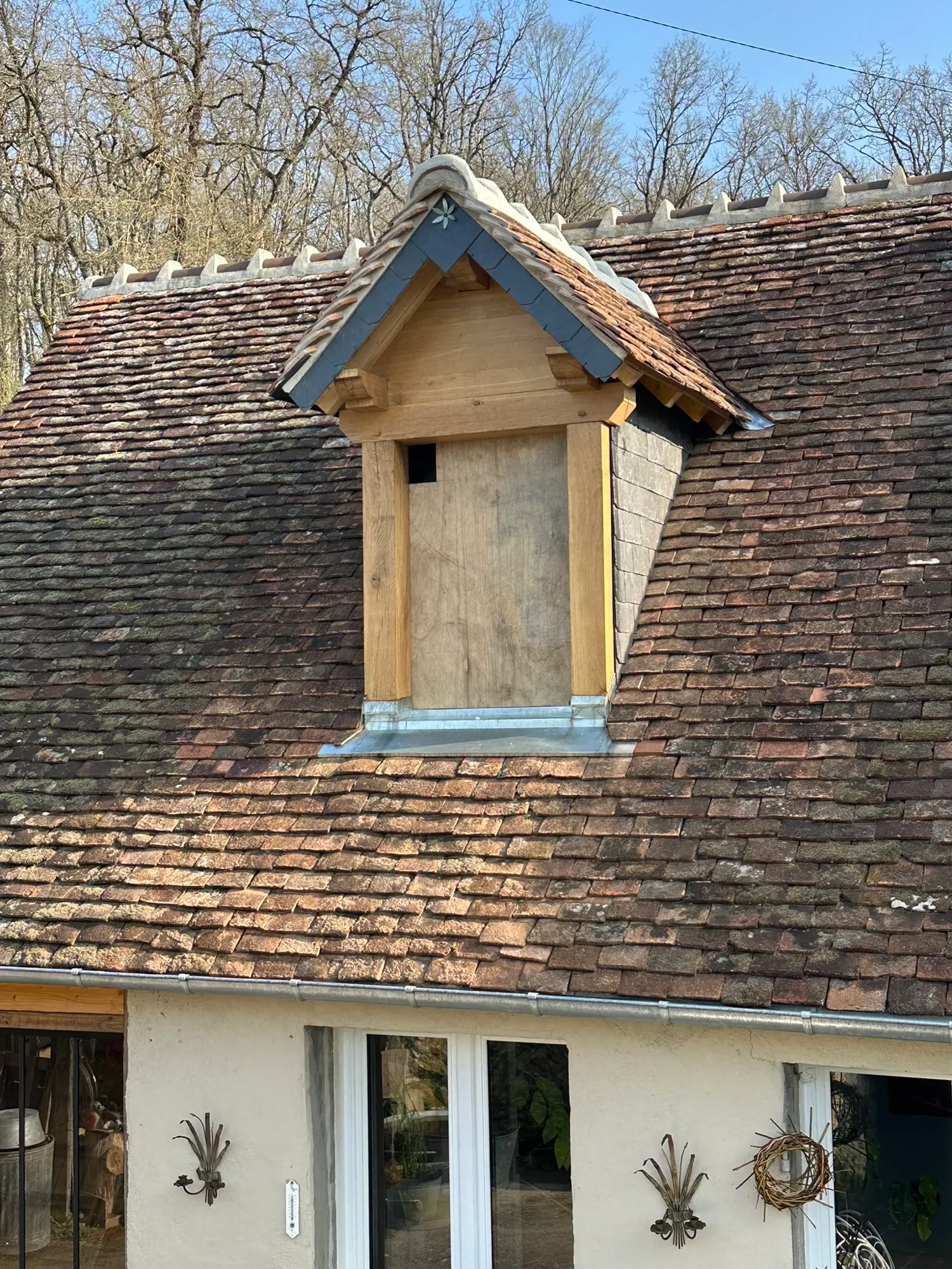 Lucarne rénovée sur toit ancien en tuiles plates