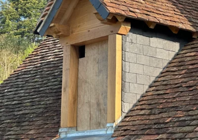 Lucarne en bois sur toiture ancienne en tuiles