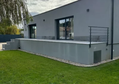 Maison contemporaine grise avec terrasse sur jardin verdoyant