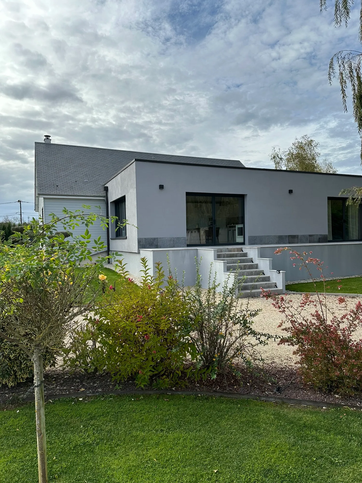 Maison contemporaine blanche avec jardin paysager et escalier