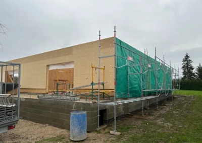 Maison en construction avec échafaudages et isolation extérieure