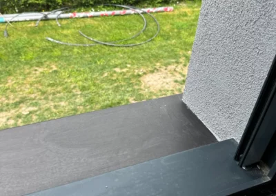 Vue sur jardin depuis une fenêtre noire