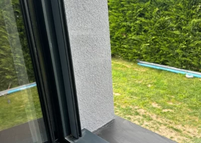Fenêtre noire ouverte sur jardin verdoyant