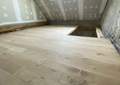 Combles aménagés avec parquet neuf et fenêtre de toit