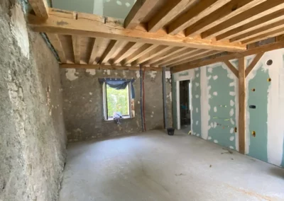 Pièce en rénovation avec poutres apparentes et cloisons en plaques