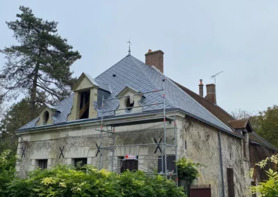 Maison ancienne avec échafaudage et toiture rénovée