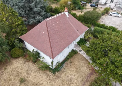 Vue aérienne d’une maison blanche au toit en tuiles