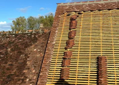 Toiture en rénovation avec liteaux et tuiles empilées