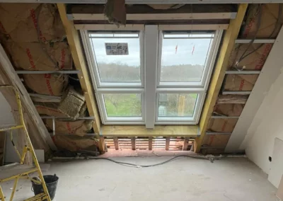 Combles en rénovation avec fenêtre double et isolation apparente